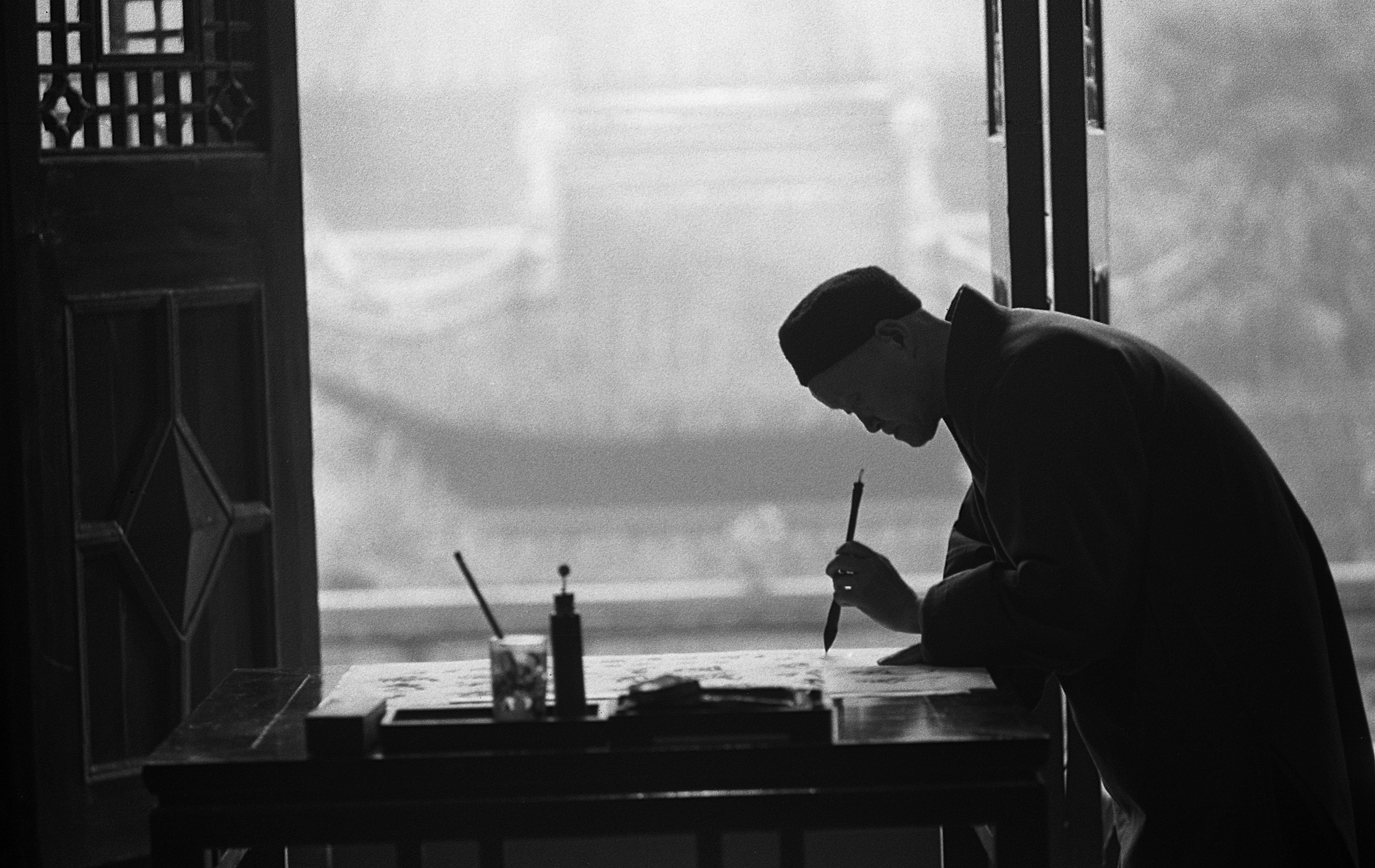 man in black suit holding pen